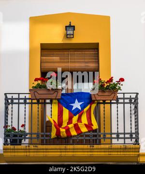 Auf dem Balkon flattert die Flagge des unabhängigen Kataloniens, geschmückt mit Topfblumen. Vilafranca del Penedes, Katalonien, Spanien Stockfoto