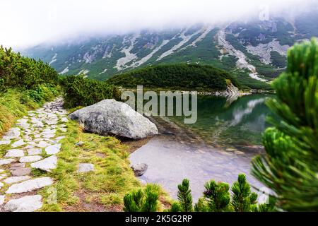 Eine sehr beeindruckende Aussicht auf die polnische Tatra mit vielen Felsen mit einem unglaublich schönen türkisfarbenen See mitten in den Bergen mit dem RE Stockfoto