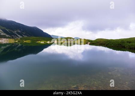 Eine sehr beeindruckende Aussicht auf die polnische Tatra mit vielen Felsen mit einem unglaublich schönen türkisfarbenen See mitten in den Bergen mit dem RE Stockfoto