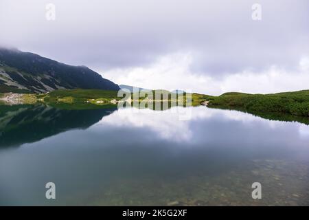 Eine sehr beeindruckende Aussicht auf die polnische Tatra mit vielen Felsen mit einem unglaublich schönen türkisfarbenen See mitten in den Bergen mit dem RE Stockfoto