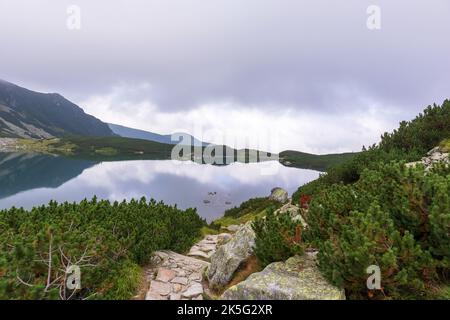 Eine sehr beeindruckende Aussicht auf die polnische Tatra mit vielen Felsen mit einem unglaublich schönen türkisfarbenen See mitten in den Bergen mit dem RE Stockfoto