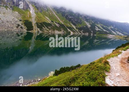 Eine sehr beeindruckende Aussicht auf die polnische Tatra mit vielen Felsen mit einem unglaublich schönen türkisfarbenen See mitten in den Bergen mit dem RE Stockfoto