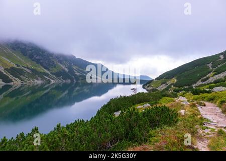 Eine sehr beeindruckende Aussicht auf die polnische Tatra mit vielen Felsen mit einem unglaublich schönen türkisfarbenen See mitten in den Bergen mit dem RE Stockfoto