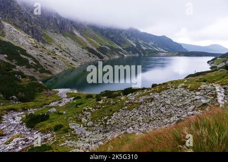 Eine sehr beeindruckende Aussicht auf die polnische Tatra mit vielen Felsen mit einem unglaublich schönen türkisfarbenen See mitten in den Bergen mit dem RE Stockfoto