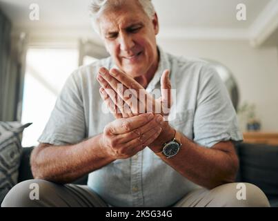 Hände, Schmerzen und Arthritis, wobei ein älterer Mann seine Hand hält, während er an Osteoporose, Krämpfen oder Verletzungen leidet. Gesundheit, Medizin und Gelenk mit einem Stockfoto