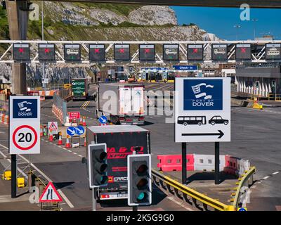 Lastwagen, die im geschäftigen Hafen von Dover in Kent, Großbritannien, ankommen. Schilder und Verkehrswege sind sichtbar. Stockfoto