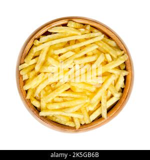 Gesalzene Kartoffelstäbchen in Holzschüssel. Auch Schuhringkartoffeln genannt. Beliebter Snack und Variante von knusprigen Kartoffelchips. Dünne Versionen von Pommes frites. Stockfoto