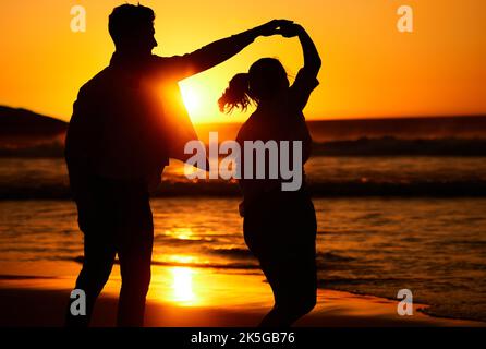 Sonnenuntergang, Tanz und Silhouette eines Paares am Strand zusammen für Liebe, Reisen und Puerto Rico Urlaub. Sommer, Sonnenaufgang und Natur mit Mann und Frau Stockfoto