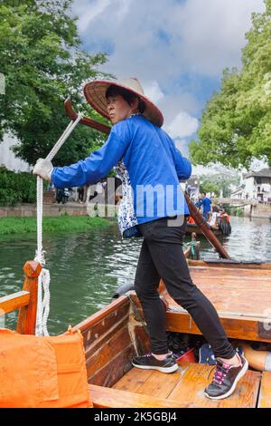 Suzhou, Jiangsu, China. Frau mittleren Alters Ruderboot für Besucher auf einem Kanal in Tongli antiken Stadt in der Nähe von Suzhou. Stockfoto