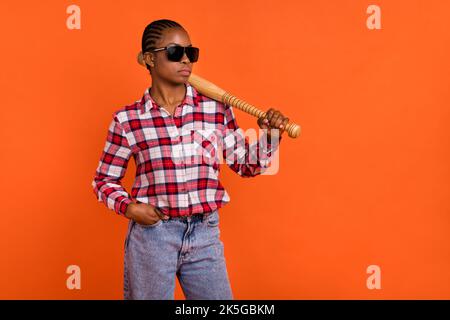 Porträt der ruhigen konzentrierten Person halten Baseballschläger isoliert auf orangen Hintergrund Stockfoto