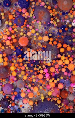Acrylfarbe Kugeln abstrakte Textur. Leuchtende Farben fließendes Tapetendesign. Violette, blaue, rosa und gelbe Flüssigkeiten mischen sich. Stockfoto