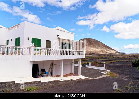 Typisch kanarisches weißes Bauernhaus auf der Insel Lanzarote in Mancha Blanca mit Vulkankrater im Hintergrund an einem sonnigen Winternachmittag. Lanzarote Ist Stockfoto