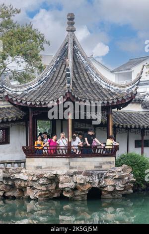 Suzhou, Jiangsu, China. Touristen im Pavillon mit Blick auf Garten, Teich, Haus des Meisters der Netze. Stockfoto