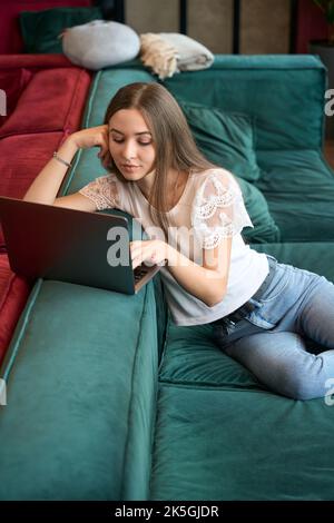 Konzentrierte freiberufliche Mitarbeiterin, die in Innenräumen an einem Laptop arbeitet Stockfoto