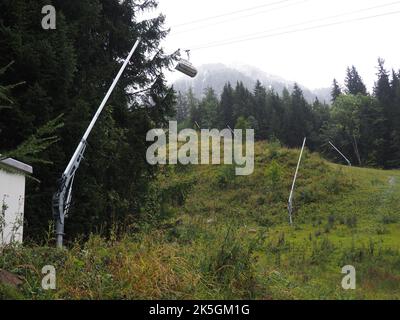 Ein Beschneiungssystem in einem Wald mit nebligen Bergen in der Ferne Stockfoto