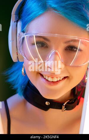 Cyberpunk-Gesicht. Generation z. Techno Mode. Porträt von schönen futuristisch lächelnden jungen Modell Frau in LED Neon-Licht Hintergrund. Stockfoto