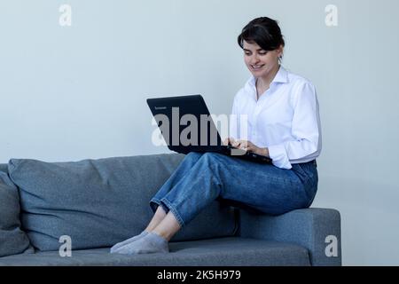 Das junge Mädchen kommuniziert in sozialen Netzwerken hinter einem Laptop. Stockfoto