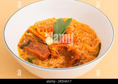 HU tieu bo kho; vietnamesisches Rindereintopf mit Reisnudeln; vietnamesisches Essen isoliert auf beigem Hintergrund; Nahaufnahme Stockfoto