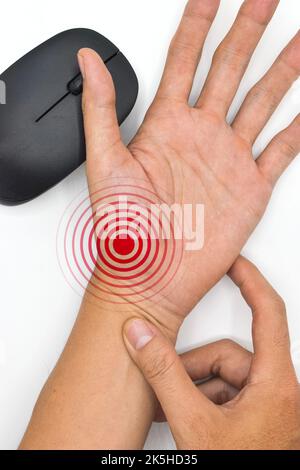 Maushand-Syndrom bei asiatischem jungen Mann. Schmerzen an der Basis des Daumens aufgrund längerer Nutzung der Computermaus. Stockfoto