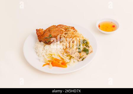 Com Tam. Gebrochener Reis mit gegrillten Schweinefleischrippen, Eierkuchen, Fischsauce, vietnamesisches Essen auf weißem Hintergrund isoliert, perspektivische Ansicht Stockfoto