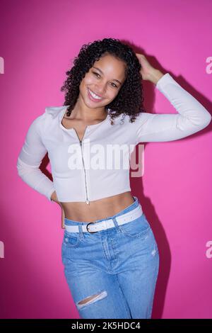 Headshot einer jungen schwarzen Schauspielerin auf einem rosa Hintergrund Stockfoto