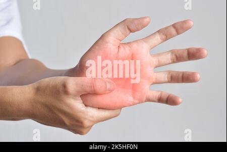 Schmerzhafter Palmar-Aspekt des asiatischen jungen Mannes. Konzept des Kompartiment-Syndroms, Zellulitis und Schmerzen der Handmuskulatur. Stockfoto