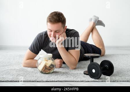 Ungesunde Lebensmittel verwirrt Mann Fitness Sport Ernährung Stockfoto