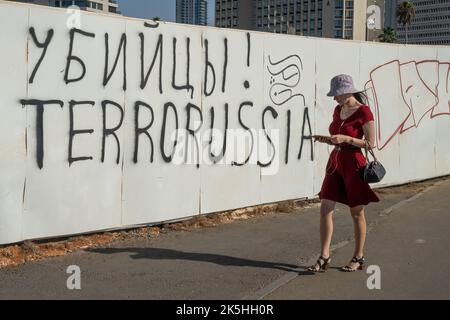 Tel Aviv, Israel - 15.. September 2022: Eine Frau, die an einem anti-russischen Graffiti in Tel Aviv, Israel, vorbeigeht. Stockfoto