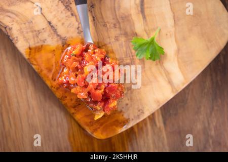 Heiße Paste aus Chilischoten und Paprika mit Öl in einem Teelöffel - Draufsicht Stockfoto