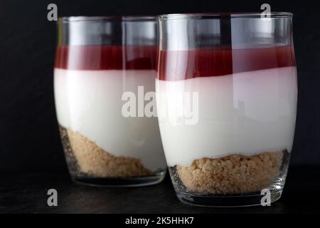 Süßes Himbeer-Dessert im Glas über dunklem Schiefer - Nahaufnahme Stockfoto
