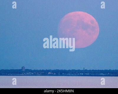 Warden Bay, Kent, Großbritannien. 8. Oktober 2022. Wetter in Großbritannien: Der fast volle Hunter's Moon, der über der Kent-Küste über Margate und Reculver aufsteigt, wurde von Warden Bay, Kent, aufgenommen. Bild: Turmblöcke in Margate. Kredit: James Bell/Alamy Live Nachrichten Stockfoto