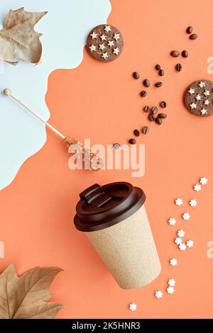 Kaffeebecher mit Naturkorkband. Kaffeetasse auf orange-weißem Herbsthintergrund mit trockenen Platanenblättern. Kaffeebohnen und Zuckerstick. Vertikal Stockfoto