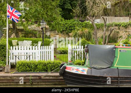 NORTHAMPTONSHIRE, Großbritannien - 25. Mai 2022. Garten am Wasser am Kanal im Dorf Stoke Bruerne, mit Schmalboot und Union Jack Stockfoto