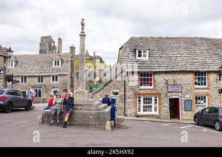 DORSET, Großbritannien - 06. Juli 2022. Touristen sitzen auf dem Queen Victoria Jubilee Monument im Corfe Castle Village Stockfoto