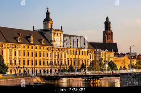 Wroclaw, Polen - 19. Juli 2022: Historisches Altstadtviertel mit Universität Wroclaw und Grodzka Straßendamm bei Sonnenuntergang über dem Fluss Warta Stockfoto