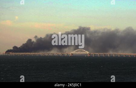 Krim, Russland. 08. Oktober 2022. Am Samstag, dem 8. Oktober 2022, explodierte in der Nähe von Kertsch ein Lastwagen, der bei einem Brand auf der Kertschbrücke, die die Krim mit Russland verbindet, schwarzen Rauch. Moskau gab bekannt, dass ein Lastwagen explodierte, der ein riesiges Feuer entzündete und die wichtige Kertsch-Brücke zerstörte, die als einzige Landverbindung Russlands mit der annektierten Krim errichtet wurde. Foto von Vladimir Mordunov/UPI. Kredit: UPI/Alamy Live Nachrichten Stockfoto