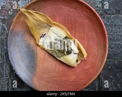 Ein Oaxacan Tamal auf einem Teller mit masa und hierba santa Stockfoto