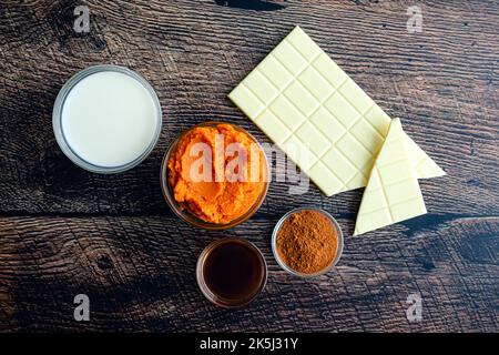 Kürbis Gewürz heiße Schokolade Zutaten: Pürierte Kürbis, weiße Schokolade und andere Zutaten von oben gesehen Stockfoto