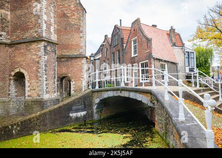 Malerische Aussicht auf alte Häuser und eine Brücke über einen Kanal in der Altstadt von Delft, Holland Stockfoto