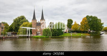 Panoramablick auf das Stadttor „Oostpoort“ und die Zugbrücke entlang des Delftse Schie-Kanals in der historischen Stadt Delft, Niederlande, an einem Herbsttag Stockfoto