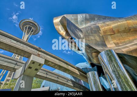 Die Monorail-Strecken von der Seattle World’s Fair mit Space Needle hinter sich führen in das Museum of Pop Culture in Seattle, Washington. Stockfoto