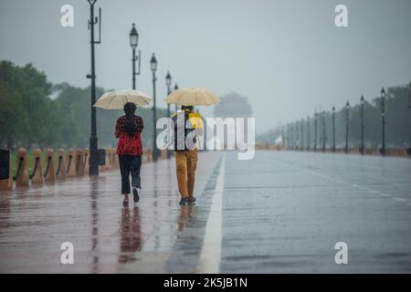 Neu-Delhi, Indien. 08. Oktober 2022. Indische Touristen, die Regenschirme halten, gehen in der Nähe des India Gate auf dem Kartavya Path (früher Rajpath). (Foto von Pradeep Gaur/SOPA Images/Sipa USA) Quelle: SIPA USA/Alamy Live News Stockfoto