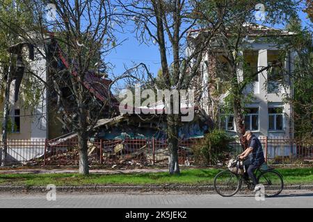 Ein Mann fährt mit dem Fahrrad an einem Kindergarten vorbei, der von einem russischen Beschuss in Sloviansk zerstört wurde. In den letzten Wochen hat die ukrainische Armee in einer erfolgreichen Gegenoffensive große Teile des Territoriums zurückerobert, die russische Truppen gezwungen hat, lange gehaltene Positionen aufzugeben. In dem, was Kiew als Moskaus Reaktion auf seine Niederlagen beschreibt, hat Präsident Wladimir Putin vier teilweise besetzte Regionen der Ukraine eingegliedert. Die Annexionen, die weithin als illegal abgetan wurden, haben Befürchtungen über eine mögliche Eskalation im siebenmonatigen Krieg geweckt. Stockfoto