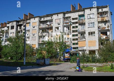 Slowiansk, Donezk, Ukraine. 8. Oktober 2022. Eine Frau kommt an einem Wohngebäude vorbei, das durch einen russischen Beschuss in Sloviansk schwer beschädigt wurde. In den letzten Wochen hat die ukrainische Armee in einer erfolgreichen Gegenoffensive große Teile des Territoriums zurückerobert, die russische Truppen gezwungen hat, lange gehaltene Positionen aufzugeben. In dem, was Kiew als Moskaus Reaktion auf seine Niederlagen beschreibt, hat Präsident Wladimir Putin vier teilweise besetzte Regionen der Ukraine eingegliedert. Die Annexionen, die weithin als illegal abgetan wurden, haben Befürchtungen über eine mögliche Eskalation im siebenmonatigen Krieg geweckt. (Bild: © Andriy An Stockfoto