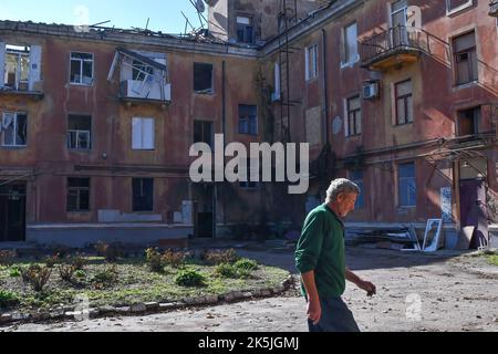 Slowiansk, Donezk, Ukraine. 8. Oktober 2022. Anwohner gehen auf den Hof eines Gebäudes, das durch einen russischen Beschuss in Slowjansk schwer beschädigt wurde. In den letzten Wochen hat die ukrainische Armee in einer erfolgreichen Gegenoffensive große Teile des Territoriums zurückerobert, die russische Truppen gezwungen hat, lange gehaltene Positionen aufzugeben. In dem, was Kiew als Moskaus Reaktion auf seine Niederlagen beschreibt, hat Präsident Wladimir Putin vier teilweise besetzte Regionen der Ukraine eingegliedert. Die Annexionen, die weithin als illegal abgetan wurden, haben Befürchtungen über eine mögliche Eskalation im siebenmonatigen Krieg geweckt. (Bild: © Stockfoto