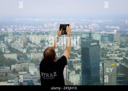 Warschau, Polen. 08. Oktober 2022. Ein Mann macht ein Foto, nachdem er am 08. Oktober 2022 den Varso-Turm in Warschau, Polen, hochgefahren hat. Die Teilnehmer liefen 53 Stockwerke hoch über den mehr als 300 Meter hohen Wolkenkratzer, Europas höchstes Gebäude, wobei die schnellsten Läufer den Wettbewerb in etwas mehr als 7 Minuten absolvten. Das während des Wettbewerbs gezogene Geld wird für ukrainische Wohltätigkeitsorganisationen verwendet. (Foto von Jaap Arriens/Sipa USA) Quelle: SIPA USA/Alamy Live News Stockfoto