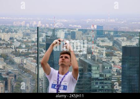 Warschau, Polen. 08. Oktober 2022. Am 08. Oktober 2022 macht ein Mann ein Selfie auf der Terrasse des Varso-Turms in Warschau, Polen. Die Teilnehmer liefen 53 Stockwerke hoch über den mehr als 300 Meter hohen Wolkenkratzer, Europas höchstes Gebäude, wobei die schnellsten Läufer den Wettbewerb in etwas mehr als 7 Minuten absolvten. Das während des Wettbewerbs gezogene Geld wird für ukrainische Wohltätigkeitsorganisationen verwendet. (Foto von Jaap Arriens/Sipa USA) Quelle: SIPA USA/Alamy Live News Stockfoto