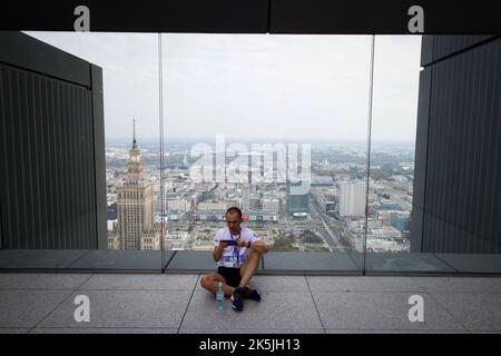 Warschau, Polen. 08. Oktober 2022. Am 08. Oktober 2022 ruht auf dem Varso-Turm in Warschau, Polen, ein Läufer. Die Teilnehmer liefen 53 Stockwerke hoch über den mehr als 300 Meter hohen Wolkenkratzer, Europas höchstes Gebäude, wobei die schnellsten Läufer den Wettbewerb in etwas mehr als 7 Minuten absolvten. Das während des Wettbewerbs gezogene Geld wird für ukrainische Wohltätigkeitsorganisationen verwendet. (Foto von Jaap Arriens/Sipa USA) Quelle: SIPA USA/Alamy Live News Stockfoto