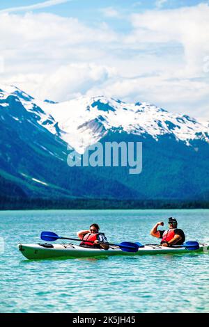 Farbenfrohe Kajakfahrer, die Witze machen; Chilkoot Lake; Chilkoot State Recreation Site; Coast Mountains; Haines; Alaska; USA Stockfoto