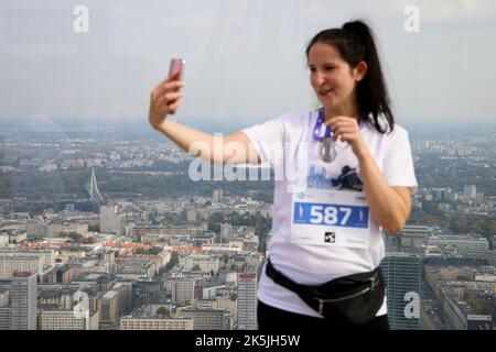 Warschau, Polen. 08. Oktober 2022. Eine Frau macht am 08. Oktober 2022 ein Selfie auf der Terrasse des Varso-Turms in Warschau, Polen. Die Teilnehmer liefen 53 Stockwerke hoch über den mehr als 300 Meter hohen Wolkenkratzer, Europas höchstes Gebäude, wobei die schnellsten Läufer den Wettbewerb in etwas mehr als 7 Minuten absolvten. Das während des Wettbewerbs gezogene Geld wird für ukrainische Wohltätigkeitsorganisationen verwendet. (Foto von Jaap Arriens/Sipa USA) Quelle: SIPA USA/Alamy Live News Stockfoto